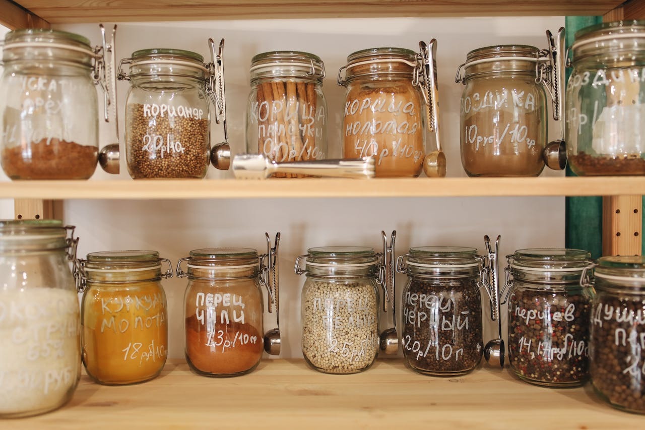 glass jars full of food on a wooden shelf